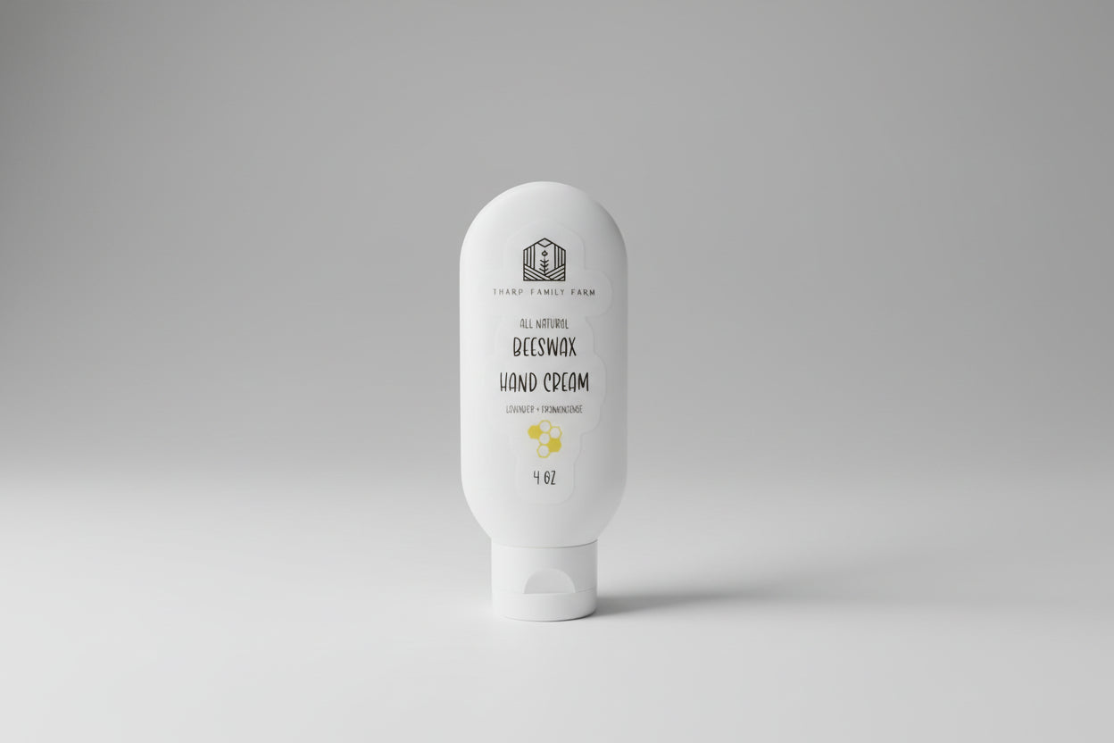 White bottle of beeswax hand cream on a textured surface