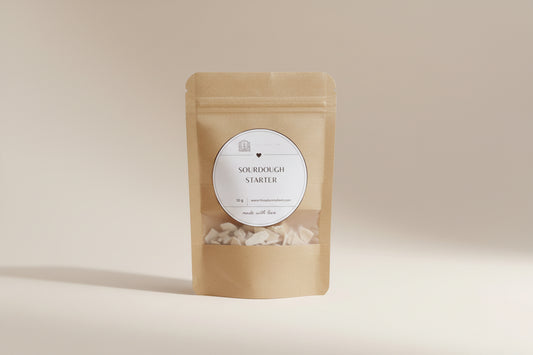 Kraft paper package with a label for sourdough starter on a wooden surface.